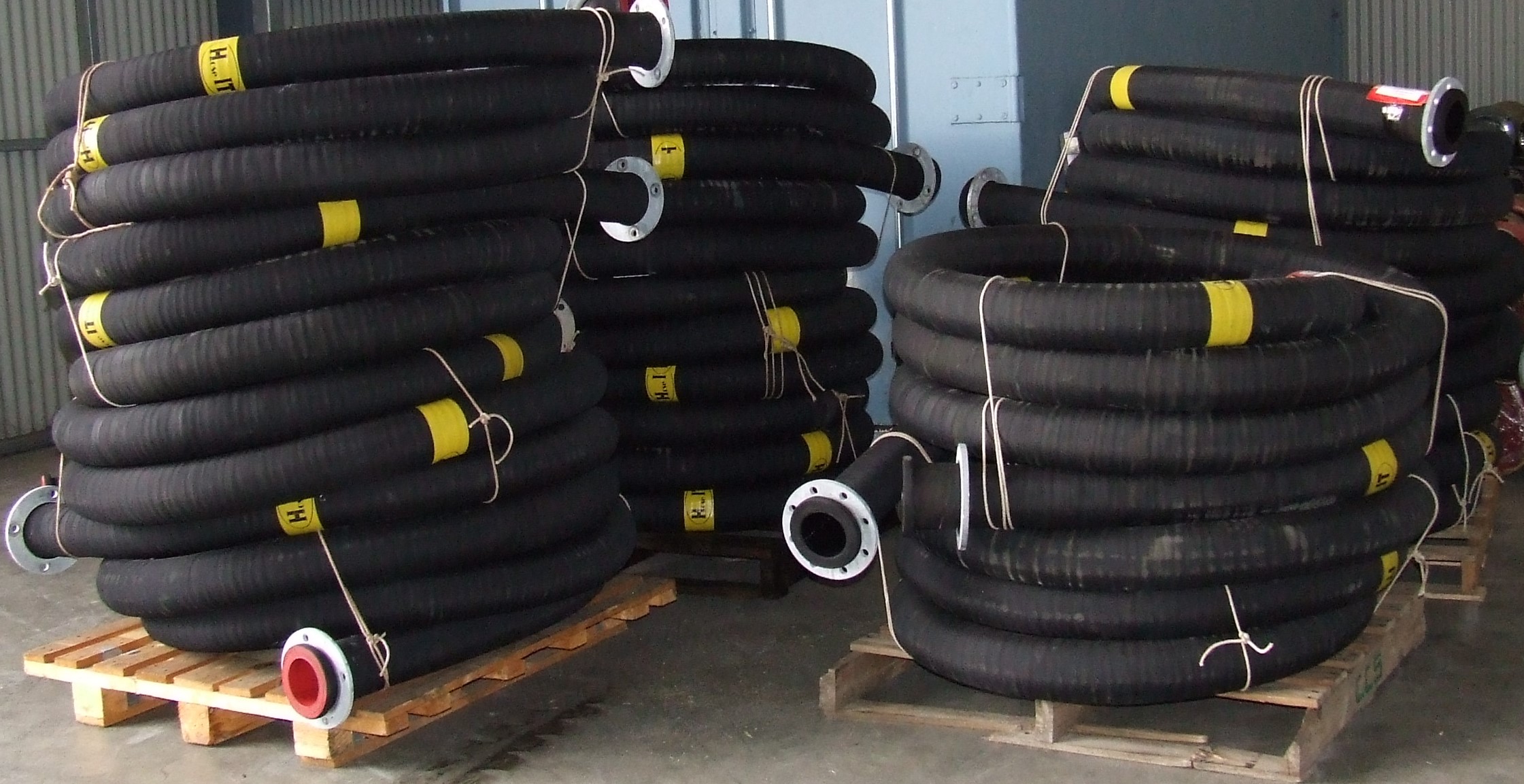 Coils of rubber mining hoses on pallets